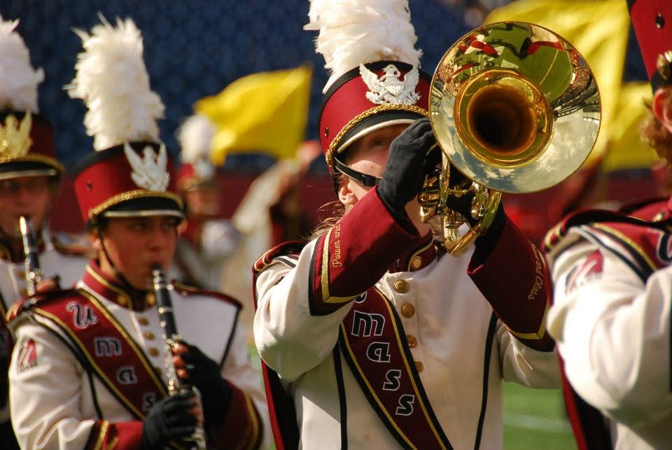 Pins can be seen on the collars of band members' uniforms